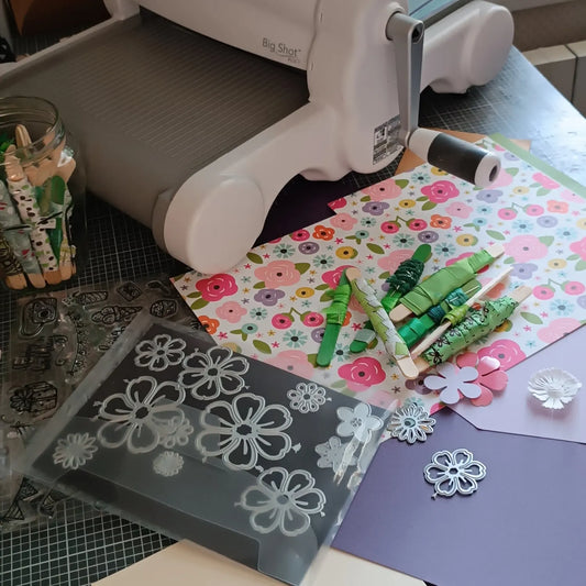 Plan de travail de scrapbooking avec papiers pastel coordonnés, ciseaux et carte artisanale en cours de création