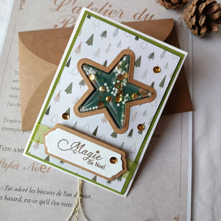 Image de la collection carte de noel artisanale - carte posée sur une table à coté d'une pomme de pin- L'ATELIER DE LILI LA SOURIS