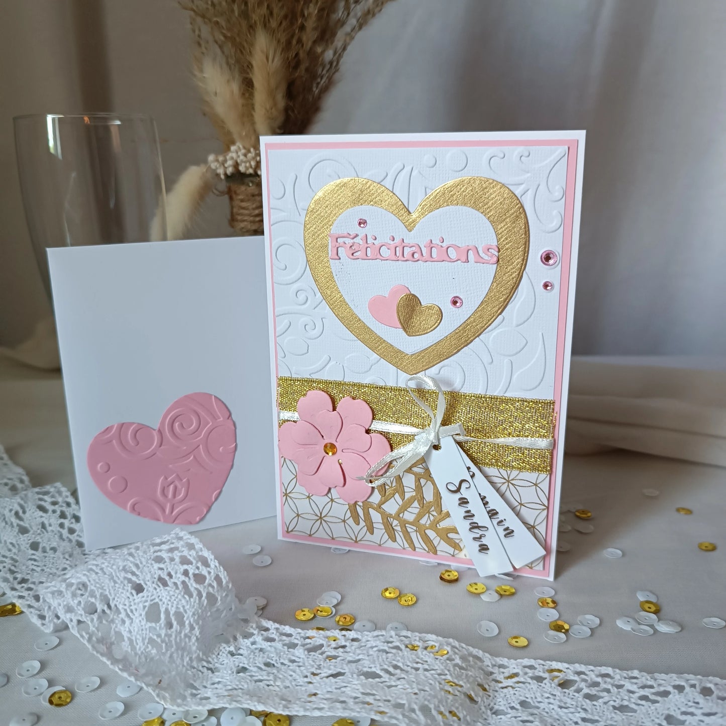 Carte de mariage rose et or présentée avec son enveloppe blanche