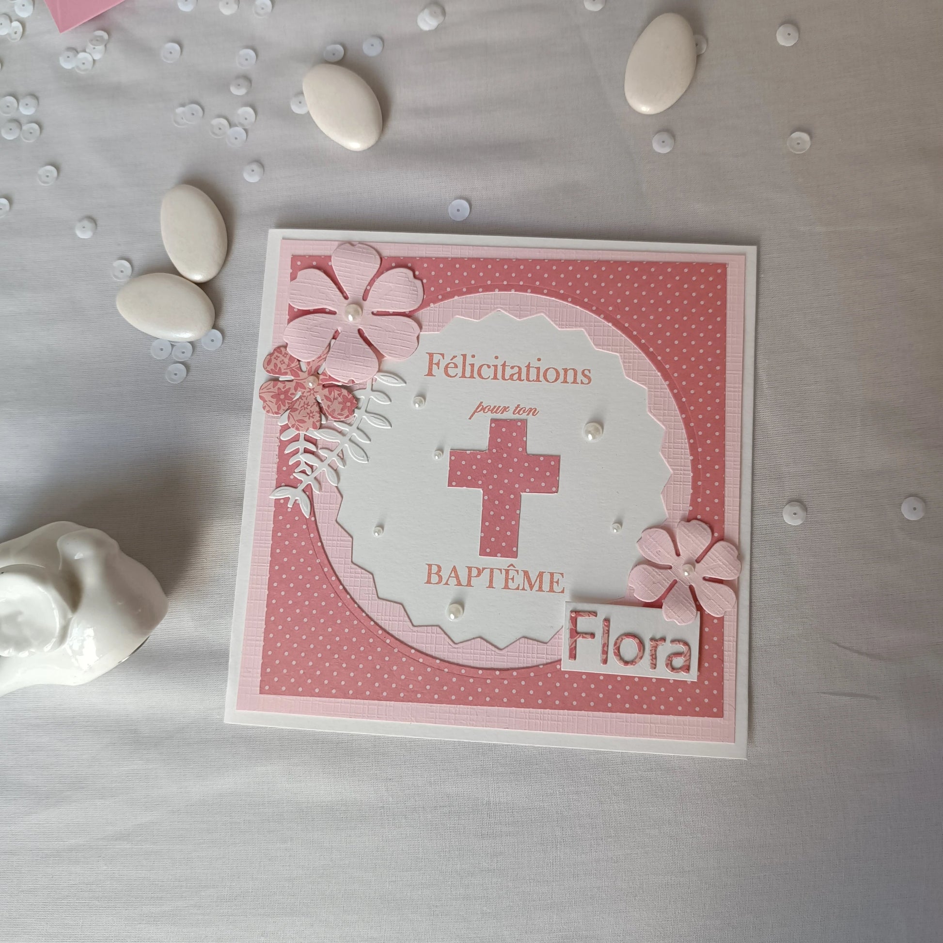 Carte de baptême rose personnalisable posée à plat