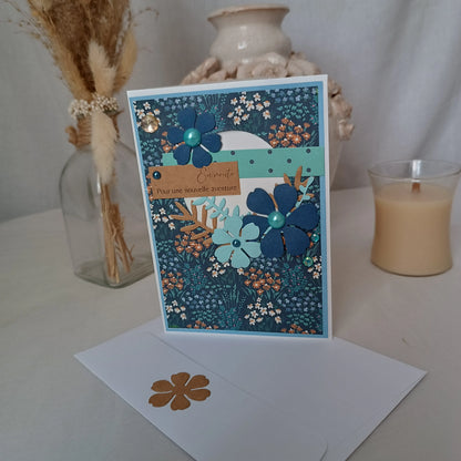 Carte de départ collègue bleu nuit debout sur son enveloppe, entourée d'un vase de fleurs séchées et d'un pot en céramique